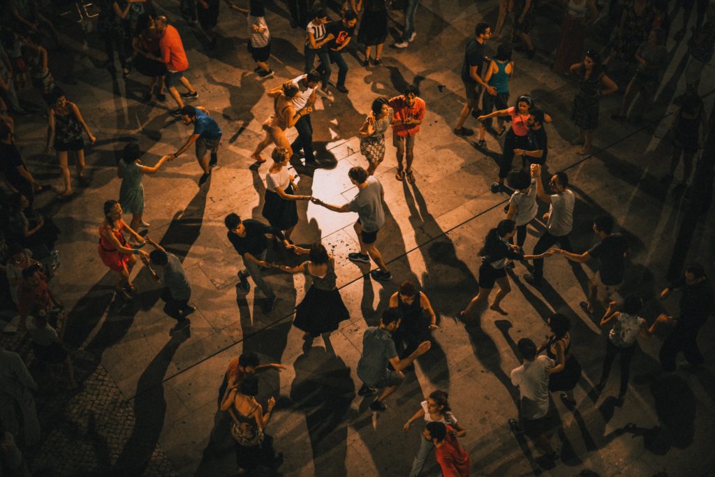 overhead shot of a large group of couples latin dancing in lowly open room