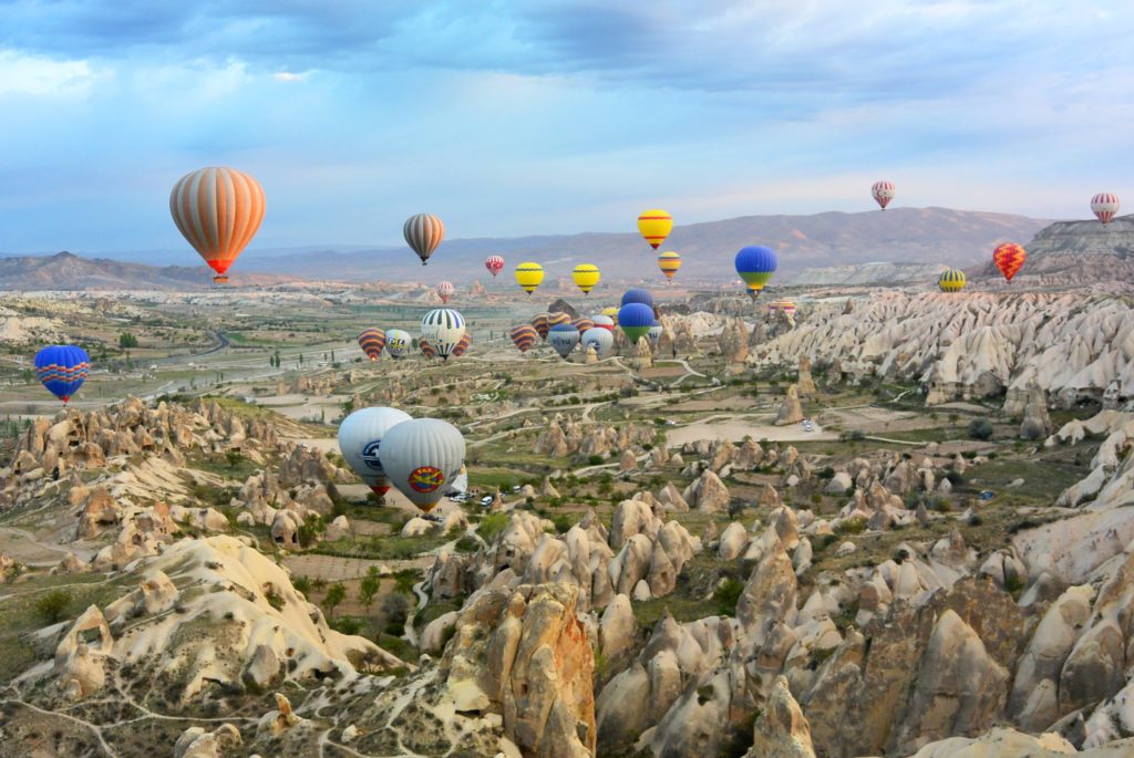 colorful hot air balloons over rocks landscape in Cappadocia, Turkey, one of the cheapest countries to visit